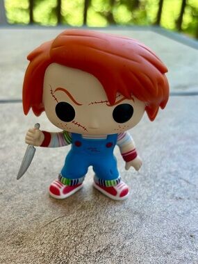 Funko Orange-Haired Chucky Figure in Blue Overalls with Multicolor Stripes